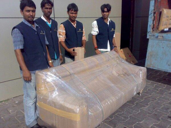 Professional movers loading household boxes into a moving truck